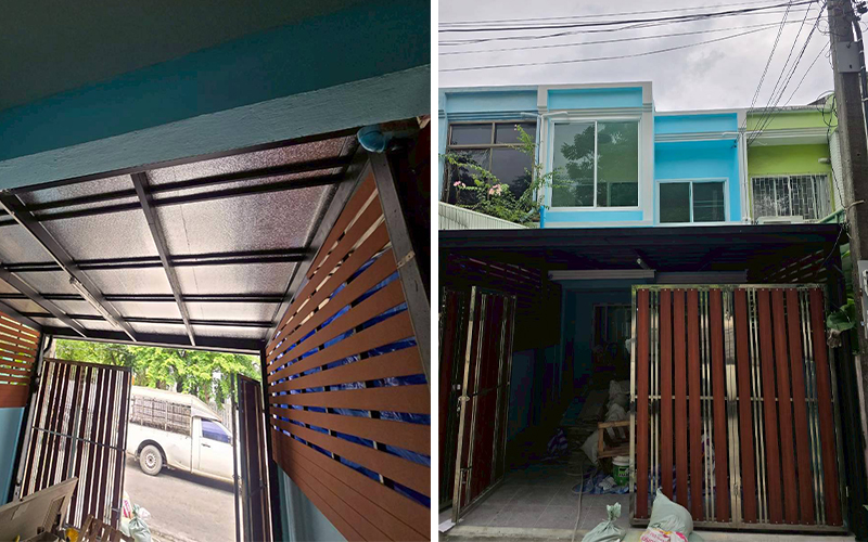 มุมมองด้านหน้า - หลังคาพร้อมแผงกั้นไม้สีน้ำตาล และหน้าบ้านสีฟ้าสะอาดตา