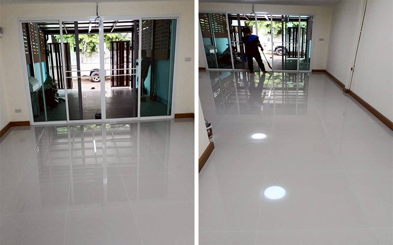 พื้นกระเบื้องขาวเงาชั้นล่างหลังเสร็จงาน - สว่างโปร่ง สะท้อนแสงธรรมชาติจากประตูบานเลื่อนด้านหน้า