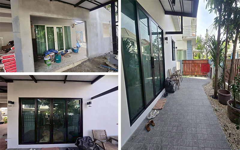 ผนังปูนฉาบเรียบสีขาว ติดตั้งบานเลื่อนกระจกดำ และทางเดินกระเบื้องเทาสะอาด